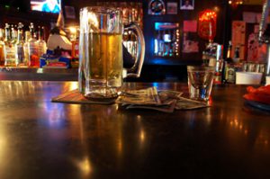 A pitcher of beer on the table at a bar.